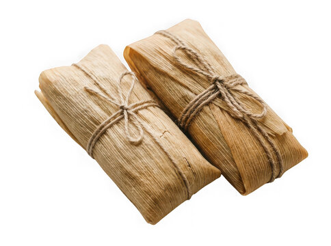 Two traditional tamales wrapped in corn husks isolated on transparent background