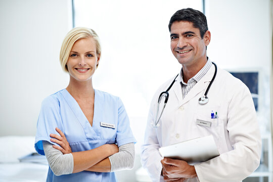 Portrait, doctor and nurse in hospital, happy for medical service, report and about us in clinic. Clipboard, healthcare team and man with woman with crossed arms, pride or wellness for health support