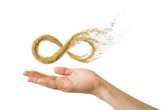 Infinity symbol made of sand floating above a human hand isolated on transparent background