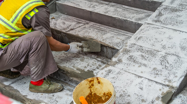 Plasterer concrete cement work. Mason using a trowel for smooth or leveling concrete slab floor work step of the building construction.