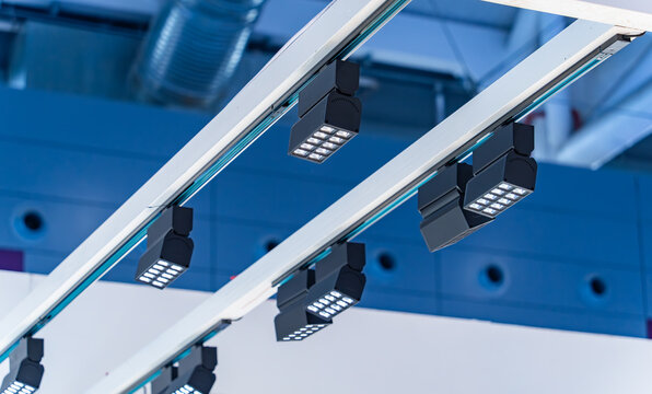 Directional LED lights on rails under the ceiling in a modern warehouse, shopping center building, office or other commercial real estate object.