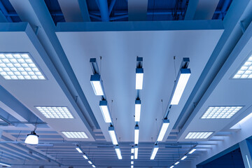 Obraz na płótnie Canvas Directional LED lights on rails under the ceiling in a modern warehouse, shopping center building, office or other commercial real estate object.