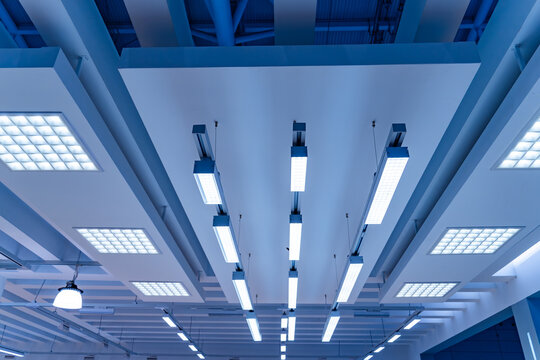Directional LED lights on rails under the ceiling in a modern warehouse, shopping center building, office or other commercial real estate object.