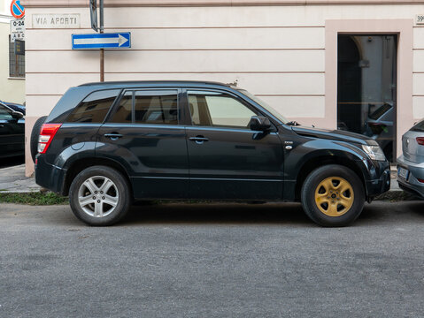 Suzuki Grand Vitara DDiS diesel SUV parked on an urban street with one gold front wheel and three silver wheels