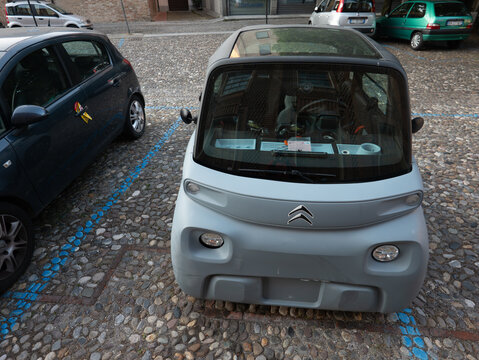 Citroen Ami electric microcar parked on cobblestone street, representing urban mobility and sustainable transport