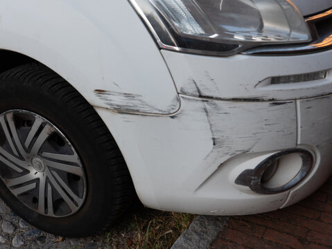 White Citroen car bumper damaged from collision, showing scratches and scuff marks requiring auto body repair