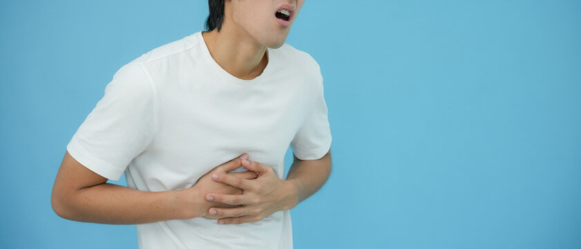 Acid reflux disease, man has symptoms of heartburn, esophageal, stomach ache, hand on chest from digestion problem after eating food at irregular times, dyspepsia, spicy food