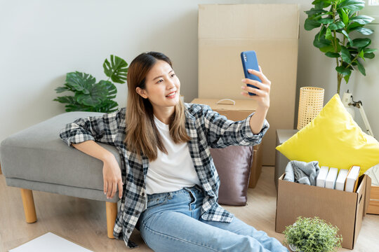Moving house, relocation. Woman selfie during move furniture for new home, inside the room was a cardboard box contain personal belongings. move in the new apartment or condominium