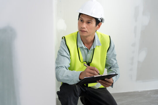 inspector or engineer is inspecting construction and quality assurance new house using a checklist. Engineers or architects or contactor work to build the house before handing it over to the homeowner