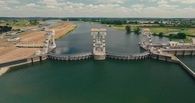 Drone pulls away from a hydroelectric power plant in a Dutch canal, revealing the dam, engineered water level difference and innovative infrastructure powering renewable energy.