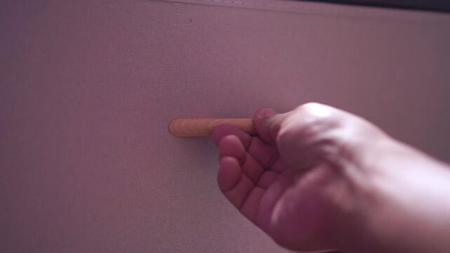 Person pulling wooden handle to shut storage drawer at home. Home organization, decluttering, and interior design concept footage.