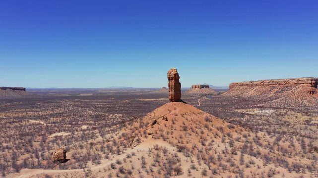 Wide aerial approach to Vingerklip rock formation in Namibia, drone establishing over desert landscape