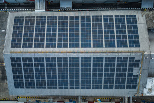 Aerial view of a large solar panel array installed on a flat industrial rooftop in Salatiga, Central Java, Indonesia.