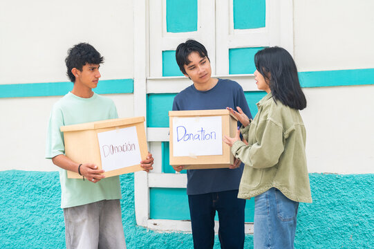 Young volunteers collecting donation boxes for charity work