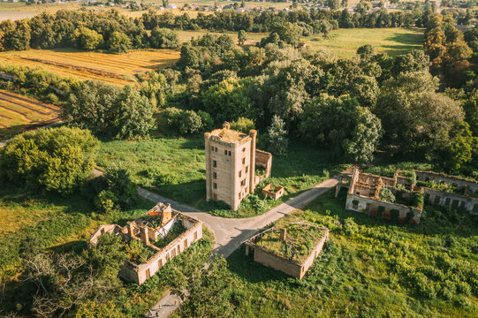 Aerial View Remains Of Yastrzhembsky Estate And Park Complex. Top View Of Old Five-storey Brick Water Tower. Drone View Of Beautiful European Nature From High Attitude In Summer Season. Bird's Eye