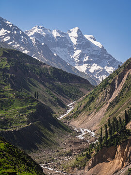 Scenic vertical landscape view of snowcapped Malika Parbat peak and rural mountain valley near Naran, Kaghan valley, Khyber Pakhtunkhwa, Pakistan