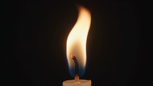 Single Candle Flame Flickering Softly in the Dark