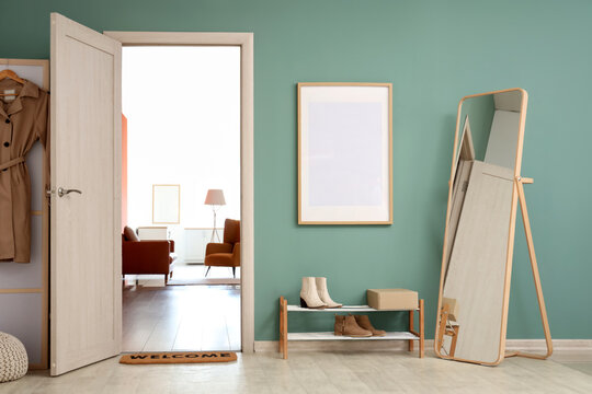 Interior of modern hallway  with floor mirror and shoes stand near mint wall