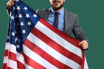 Obraz premium Young businessman with USA flag on green background. Labor Day celebration