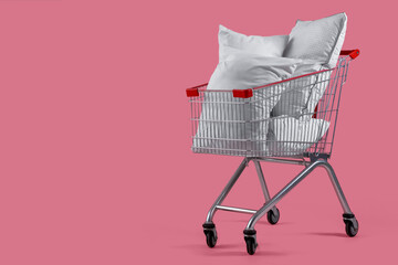 Shopping cart full of pillows on pink background © Pixel-Shot