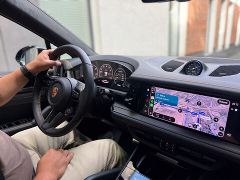 Driver inside a luxury sports car with digital dashboard and navigation screen, holding the steering wheel while driving porsche cayenne gts Poland, Pszczyna, 3.08.2026 
