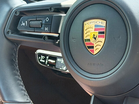 Close-up of a porsche steering wheel with logo and control buttons inside a luxury sports car interior. porsche cayenne gts Poland, Pszczyna, 3.08.2026 
