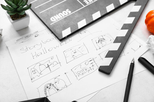 Clapperboard with storyboard and different Halloween decor on white background