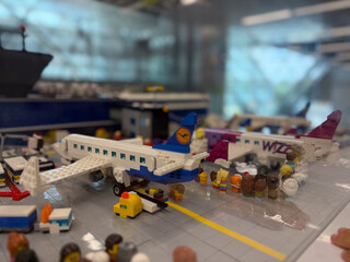 Fototapeta premium Lego airport scene with a toy airplane, passengers, and terminal details in a miniature travel display.