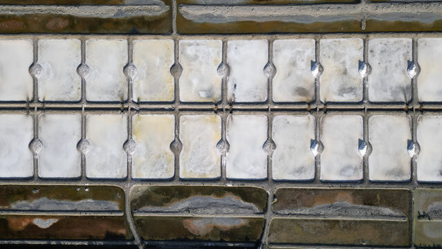 Aerial view of the geometric salt pans of the Marais salants de Guerande, showing the grid of evaporation ponds with varying textures in Guerande, Pays de la Loire, France.