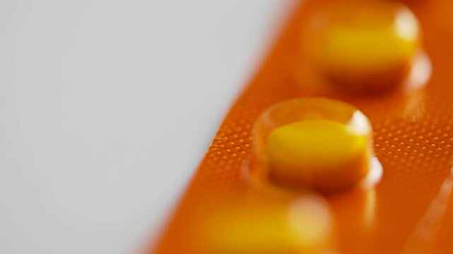Close up of yellow tablets in orange packaging