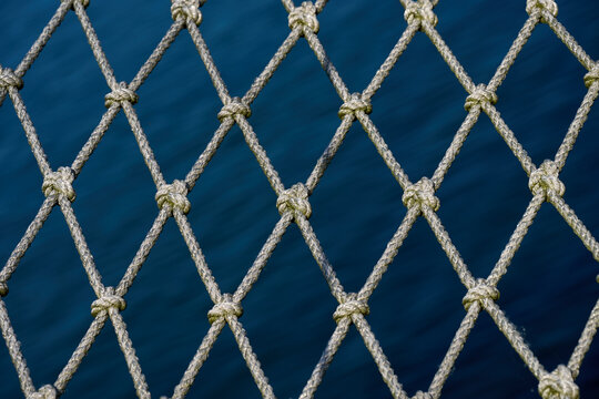 Detailed view of rope safety mesh with deep blue sea background on vessel, Gdynia, Pomerania, Poland, Baltic Sea, Europe
