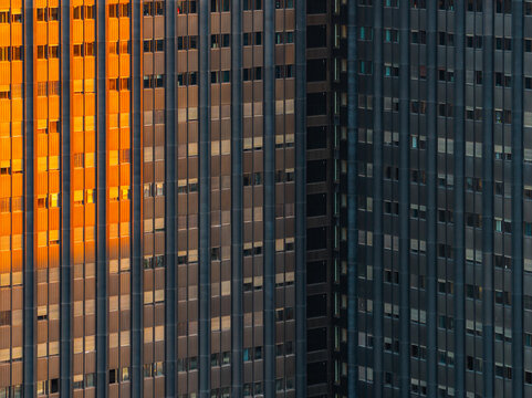 Aerial view of the modern facade of a building in the EUR district with vertical lines and golden sunlight reflections in Rome, Lazio, Italy.