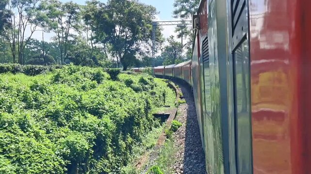 Scenic train journey view from the window passing through lush green landscape in India