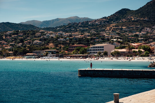 White sand beach of Ile-Rousse with the mountains behind in Corsica