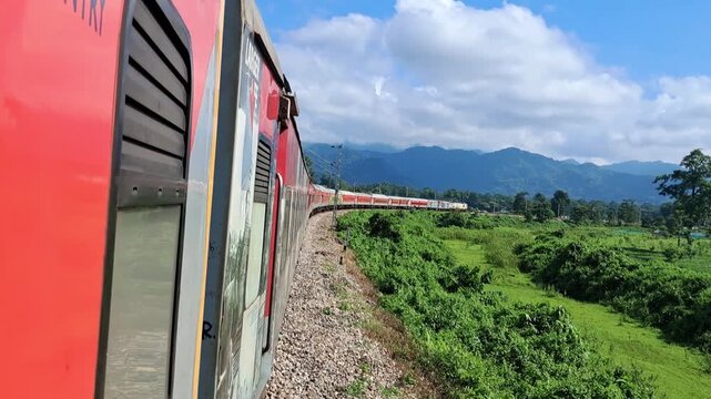 ​Indian railway train on a scenic curve track surrounded by nature and hills. Indian Railway.