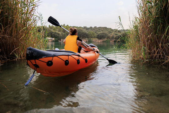 Woman kayaking on calm river exploring natural surroundings