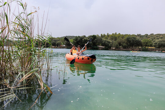 Girls paddling inflatable kayak enjoying summer lake activity