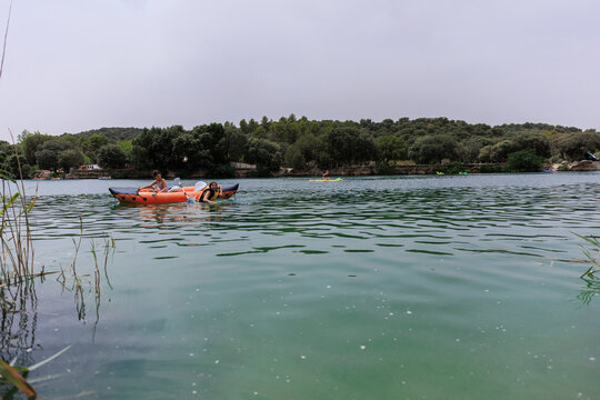 People enjoying water activities on a lake with inflatable kayak