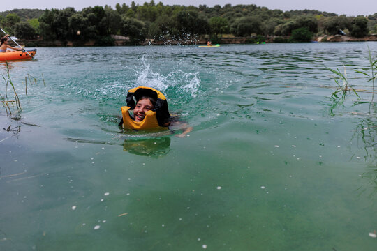 Young girl having fun swimming lake splashing water