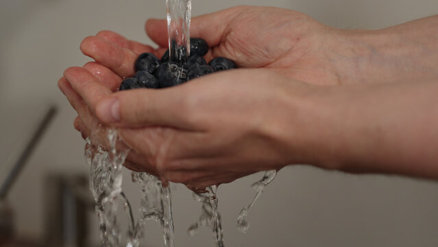 man hand wash fresh ripe blueberry