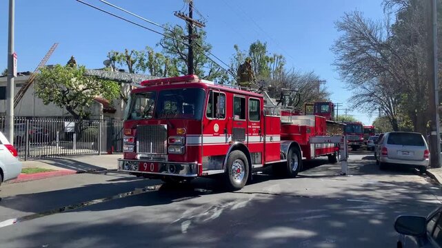 Los Angeles fire department engine parked on residential street during emergency response operation scene.