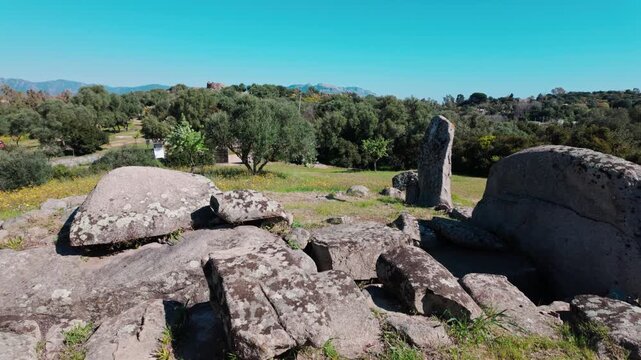 A wide shot of the prehistoric megalithic structures and giant tombs at the Nuraghe SOrtali e su Monti complex in Sardinia, Italy.