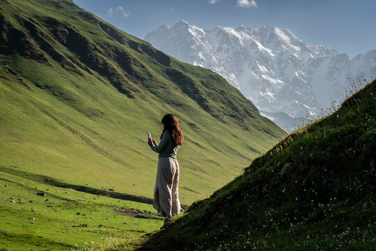 young woman silhouetted in the meadows of Ushguli village, trans-Caucasian trail, Upper Svaneti, Caucasus mountain range, Georgia