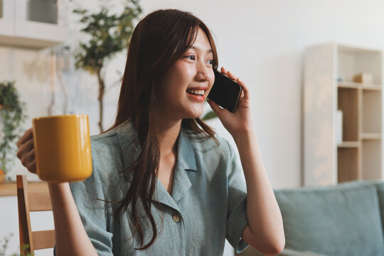 Happiness Entrepreneur beautiful business asian young woman wear casual use mobile phone for shopping online enjoy with social media and laptop at home.Small Business Startup.online banking