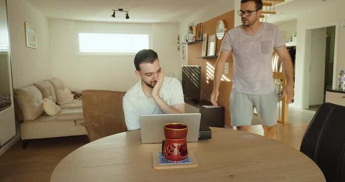 A manager throws a stack of files onto an employee's desk while the employee works on a laptop. Concept of excessive workload, workplace pressure, stress, and employee management.