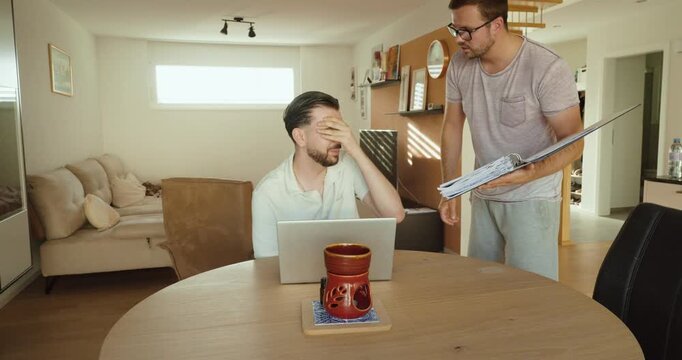 A manager confronts an employee working on a laptop, creating performance pressure in the workplace. Concept of leadership, employee management, workplace stress, and professional communication.