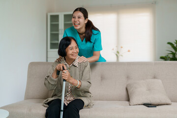 Caregiver supporting senior woman smiling at home