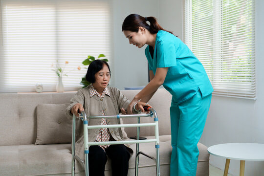 Healthcare professional assisting senior woman using walker at home