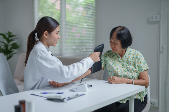 Doctor checking elderly patient blood pressure at home