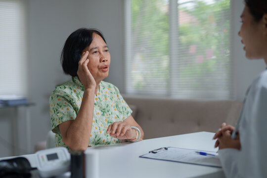 Senior woman suffering headache during medical consultation